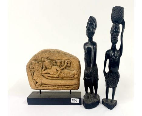 A carved stone relief panel, H. 24cm, together with two carved ebony figures.