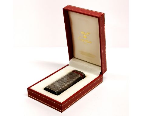 A boxed 'Must de Cartier' cigarette lighter.