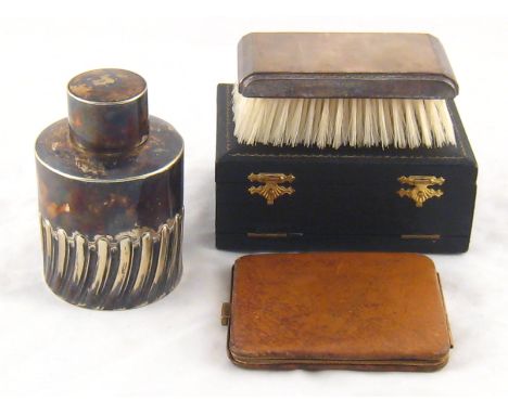 A mixed lot. A silver plated cylindrical tea caddy, a silver hair brush and comb in fitted case and a pigskin note case.