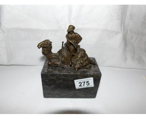 A bronze camel rider on marble plinth