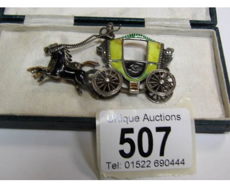 An unusual Victorian brooch depicting a coach and horses in enamel and silver