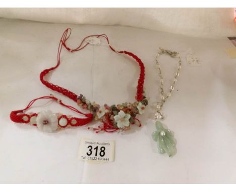 A jade 'lily' pendant on silver chain, a braided silk bracelet and necklace with jade and small precious stones