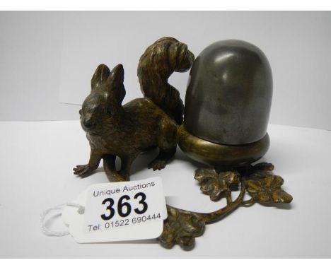 A cast metal inkwell being squirrel with nut