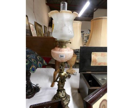 A gilded spelter cherub oil lamp with mottled amber glass font and amber tipped acid etched shade