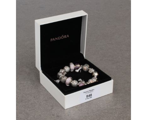 A Pandora bracelet with sixteen silver charms in pink and cream tones, all set with enamel, glass or crystals, in a Pandora b