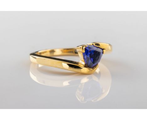 A trillion blue stone ring The trillion cut blue stone ring set in yellow metal, ring size O.