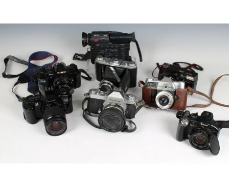 A collection of camera equipment comprisng a Nikon Nikkormat FT2 camera, Kodak Retina Reflex IV camera, Canon EOS 500 camera,