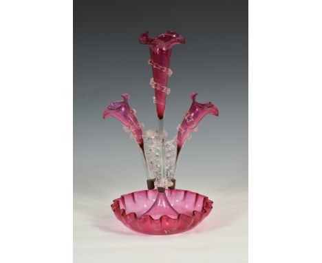 A Victorian cranberry glass epergne with central trumpet spill with wavy edge clear glass spiral decoration, flanked by two s