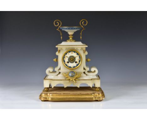 A 19th century French alabaster cased mantel clock surmounted by a squat lidless urn with gilt metal mounts and blue and gilt