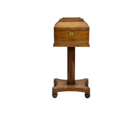 An early Victorian rosewood teapoy on a hexagonal column and base on four bun feet, containing three blue velvet lined compar