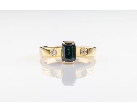 A tourmaline and diamond ring The emerald-cut blue green tourmaline flanked by brilliant cut diamonds, set in 18ct yellow gol