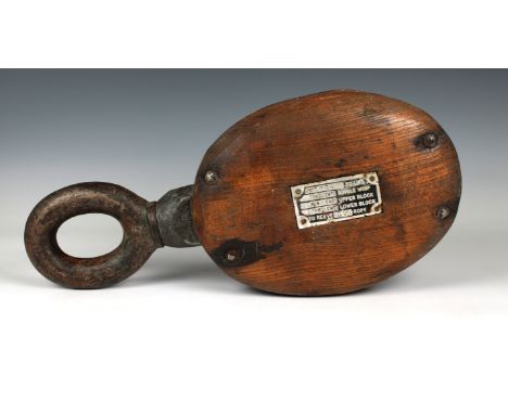 A large 19th century or earlier wooden single pulley block of typical elm construction with metal roller wheel and fittings, 