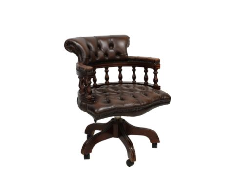 A 20th century Victorian style button back brown leather Captains chair with wood turned spindles, shaped arms and backrest, 