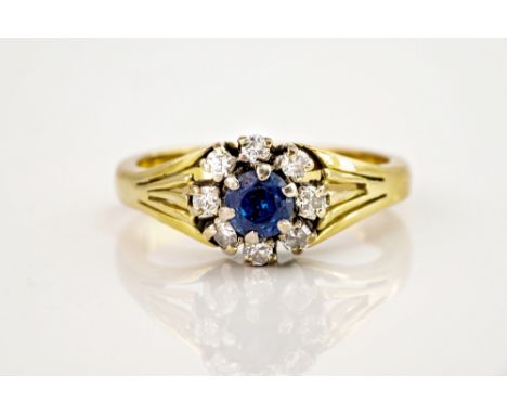 A 9ct yellow gold, sapphire and diamond cluster ring the central, round cut sapphire, approx. 0.33ct within a border of brill