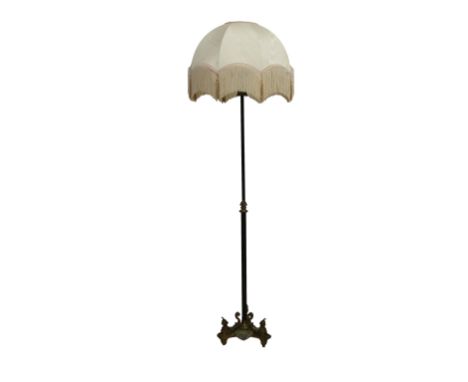 A 20th century standard lamp on a reeded column with tri form base and sphynx ornament, 55in. (139.7cm.) high.