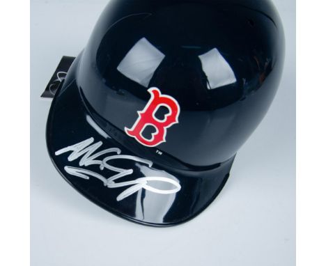 This is a miniature of an official MLB batting helmet with Boston Red Sox logo on the front and signed in silver by Nomar Gar