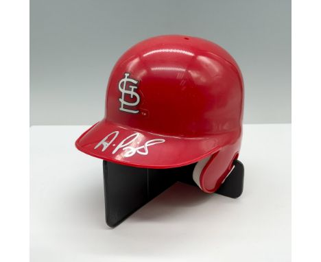 A red St. Louis Cardinals baseball helmet with a white logo, autographed by Albert Pujols in silver ink. Albert Pujols signat