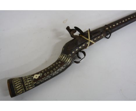 AN ANTIQUE ORNATE APPEARANCE AFGHAN FLINTLOCK JAZAIL, fitted with a barrel which is approximately 47 '' long, it's stock is i