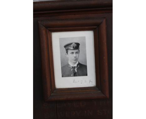 A LARGE WOODEN FRAME/PLAQUE FEATURING A SMALL BLACK AND WHITE PHOTO OF BASIL J.D. GUY V.C., together with a signature, enclos