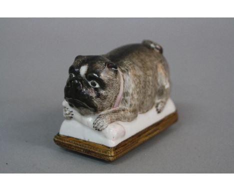A 19TH CENTURY CONTINENTAL ENAMEL AND PORCELAIN SNUFF BOX, of recumbant Pug form, with pink collar and bone between front paw