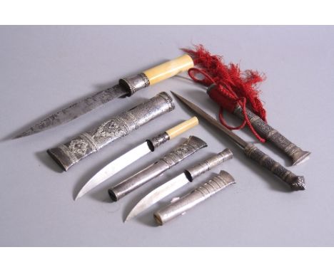 FOUR MIDDLE EASTERN WHITE METAL DAGGERS, two with ivory handles, three with filigree overlay, approximate lengths including s