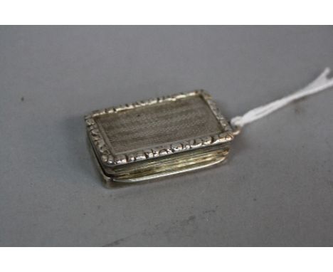 AN EARLY 19TH CENTURY SILVER VINAIGRETTE, rectangular with cast rim and engine turned decoration, the plain cover engraved 'N