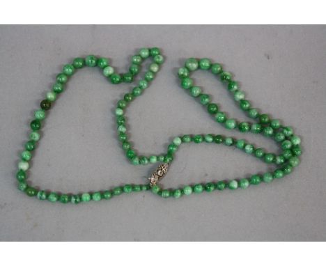 A GRADUATED GREEN JADE BEAD DOUBLE ROW NECKLACE, the round beads graduated from 5.4mm to 8.6mm in diameter, measuring approxi