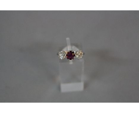 A LATE 19TH TO EARLY 20TH CENTURY DIAMOND AND RUBY THREE STONE RING, two old cushion cut diamonds, estimated total diamond we