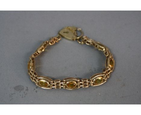 A LATE 20TH CENTURY 9CT GOLD CITRINE GATE LINK BRACELET, seven oval mixed cut citrines measuring approximately 7mm x 5mm, bra