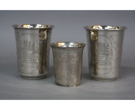 A PAIR OF EARLY 20TH CENTURY RUSSIAN SILVER CONICAL BEAKERS, engraved with alternating panels of buildings and vase of foliag