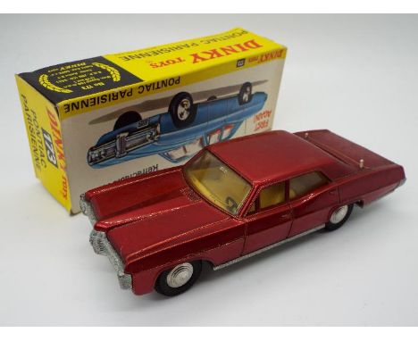 Dinky Toys - A boxed Dinky Toys #173 Pontiac Parisienne. Finished in a metallic red with yellow interior, the model features 