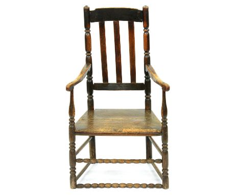 A George III elm armchair, with boarded seat and bobbin stretchers, seat height 37cm  Wear to legs, originally slightly highe
