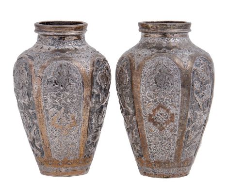 A pair of Middle Eastern silver coloured metal repousse vases, early 20th c, shouldered oviform and decorated with arched res