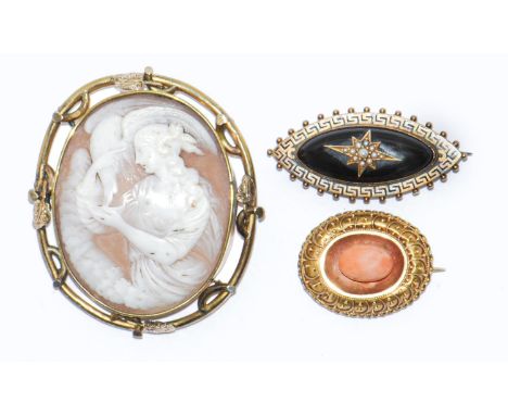 A Victorian gold brooch, set with a coral bead in filigree border, a Victorian shuttle shaped gold and black enamel mourning 