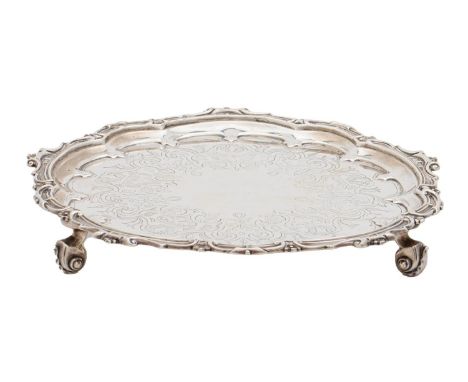 A Victorian silver salver, the field engraved with strapwork, in conforming strapwork border, on three volute feet, 25cm diam