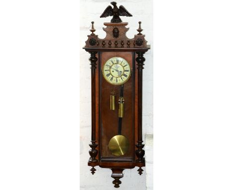 A walnut&nbsp; and ebonised Vienna wall clock, late 19th c, the architectural pediment with eagle finial above mask rosettes,
