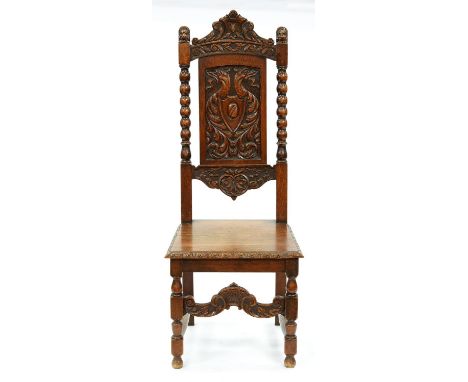 A Victorian carved oak hall chair,&nbsp; the crested back flanked by lions' heads, the panel carved with dragons flanked by b