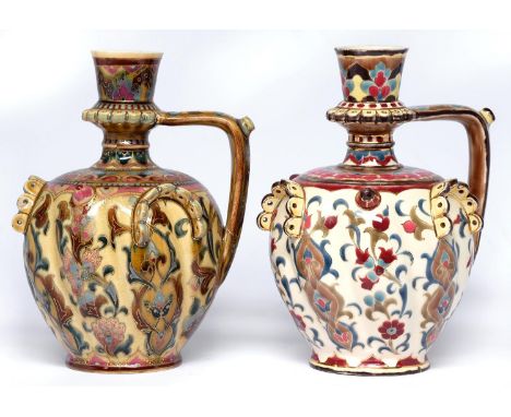 Two Zsolnay ewers, late 19th c, spirally lobed and studded, with spouted handle and decorated with spiralling foliage, 29cm h
