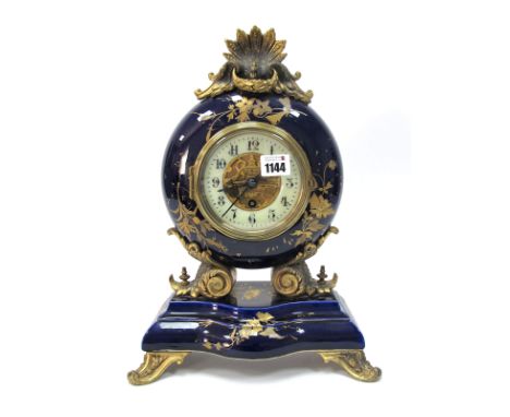 A Late XIX Century French Mantle Clock, the blue pottery ormolu mounted case decorated with flowers and of circular form with