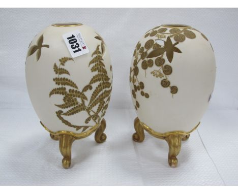 A Pair of Royal Worcester Porcelain Vases, of pierced ovoid form raised on scrolling feet, the old ivory grounds painted in g