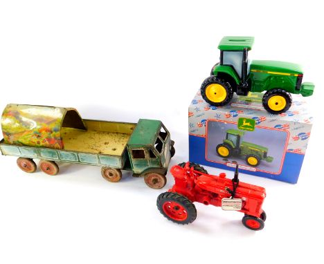 An Ertl die cast McCormick Farmall tractor, John Deere collectable savings bank modelled as a tractor, boxed and a tin plate 