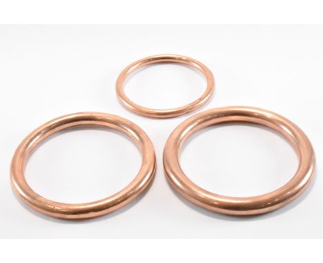 A group of three gold and silver lined bangle bracelets. Each bracelet of round tubular form. All marked 9ct silver lined. We