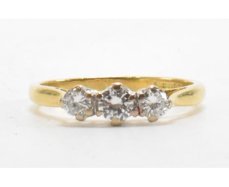 A hallmarked 18ct gold and diamond three stone ring. The ring being set with three round brilliant cut diamonds. Diamonds est