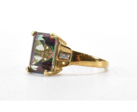 A hallmarked 9ct gold and Mystic topaz cocktail ring. The ring set with a octagon mixed cut Mystic topaz in a four claw setti