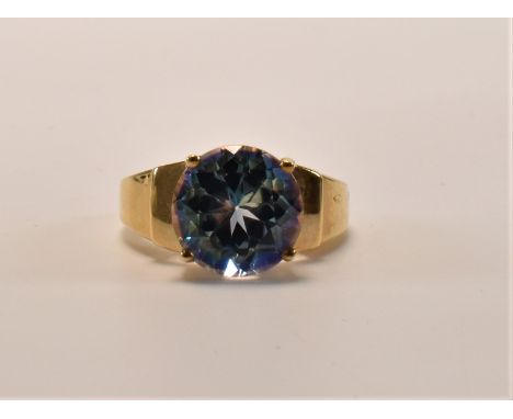 A hallmarked 9ct gold and Neptune topaz cocktail ring. The ring set with a round mixed cut Neptune topaz in a four claw setti
