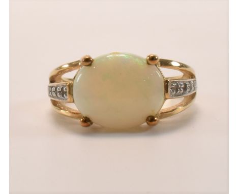 A hallmarked 9ct gold opal and topaz ring. The ring set with and oval Andamooka opal which exhibits full spectrum play of col