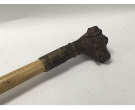 A sword stick the bronze handle in the form of a dogs head .