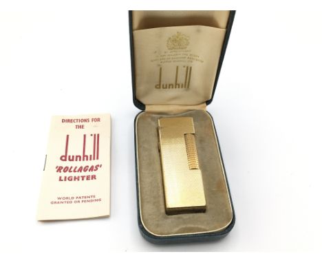 A vintage Dunhill gold tone lighter with case and paperwork.Postage B