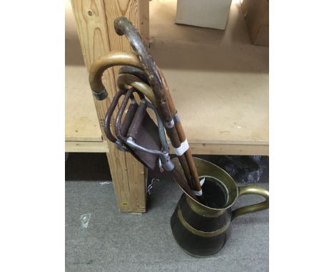 A large brass bound wooden jug with hallmarked silver rimmed walking sticks and a shooting stick