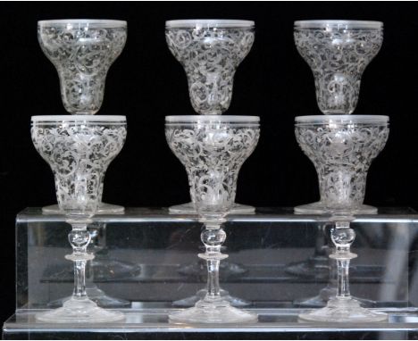 A set of six late 19th Century Continental drinking glasses, pan top bowl enamel decorated with repeat foliate scrolls above 